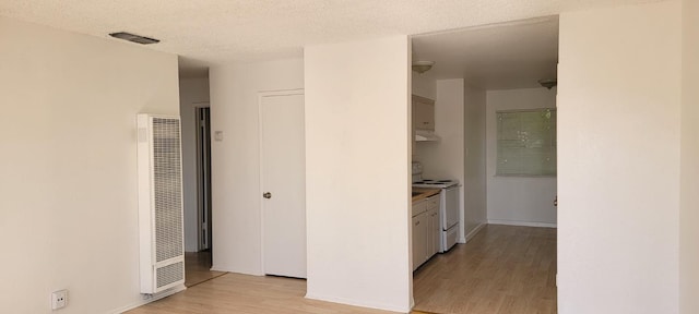 2025 E White Ave, Fresno, CA 93701 - corridor with a heating unit, light wood-style floors, baseboards, and a textured ceiling