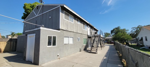 2025 E White Ave, Fresno, CA 93701 - view of side of home featuring stairs, stucco siding, a patio, and board and batten siding