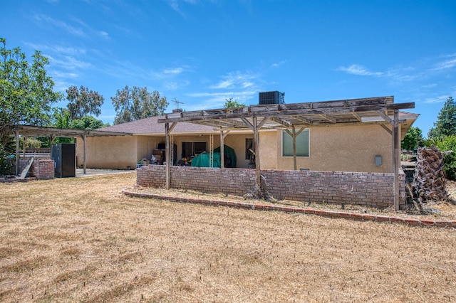 7820 N Fancher Rd, Clovis, CA 93619 - back of property featuring a pergola, stucco siding, and central AC unit