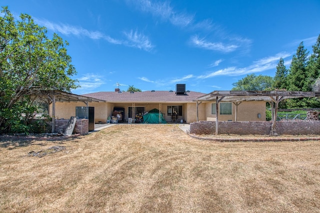 7820 N Fancher Rd, Clovis, CA 93619 - back of house featuring a pergola, stucco siding, central air condition unit, and a lawn