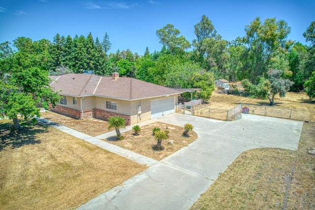 7820 N Fancher Rd, Clovis, CA 93619 - view of front facade with driveway, an attached garage, and a chimney