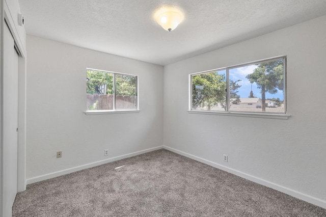 4824 E Brown Ave, Fresno, CA 93703 - unfurnished bedroom with carpet flooring, baseboards, a closet, and a textured ceiling