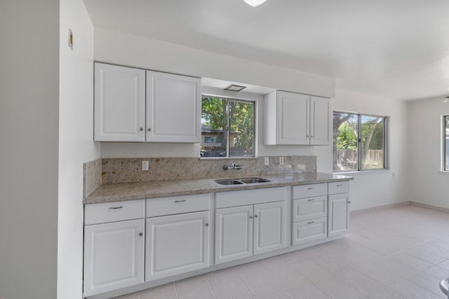 4824 E Brown Ave, Fresno, CA 93703 - kitchen featuring a sink, white cabinets, light stone countertops, and light tile patterned floors