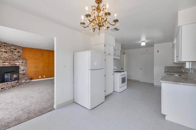 4824 E Brown Ave, Fresno, CA 93703 - kitchen featuring white appliances, a wood stove, a sink, white cabinetry, and light tile patterned floors
