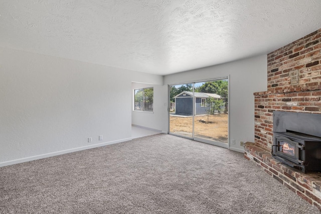 4824 E Brown Ave, Fresno, CA 93703 - unfurnished living room featuring a wood stove, a textured ceiling, baseboards, and carpet