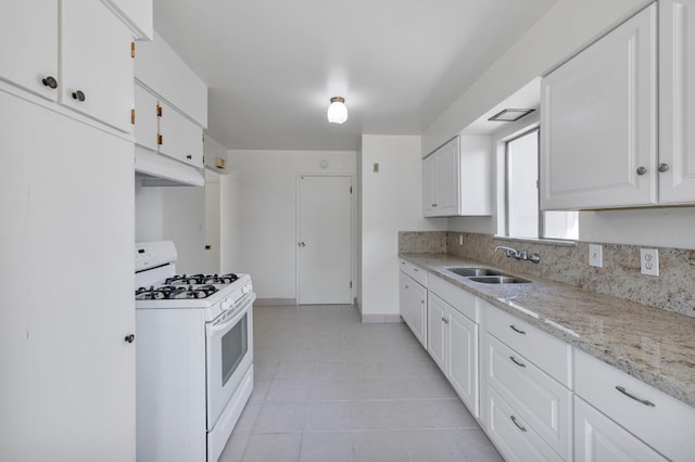 4824 E Brown Ave, Fresno, CA 93703 - kitchen featuring white gas range oven, a sink, under cabinet range hood, light tile patterned flooring, and white cabinetry