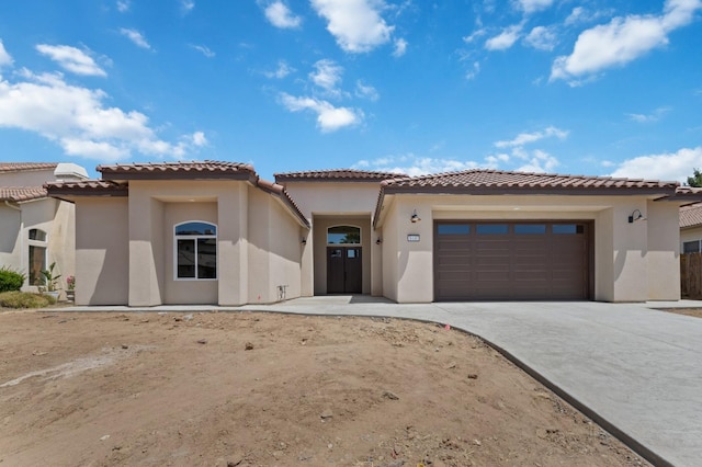 8440 Lake Shore Dr, Chowchilla, CA 93610 - mediterranean / spanish-style house featuring an attached garage, stucco siding, concrete driveway, and a tiled roof