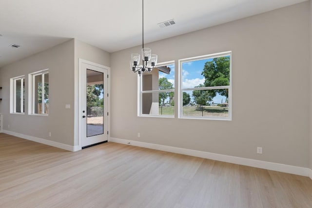 8440 Lake Shore Dr, Chowchilla, CA 93610 - unfurnished dining area with a chandelier, light wood finished floors, baseboards, and plenty of natural light