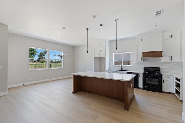 8440 Lake Shore Dr, Chowchilla, CA 93610 - kitchen with black appliances, a sink, light wood-type flooring, a center island, and tasteful backsplash
