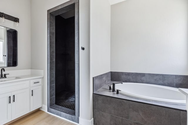 8385 Lake Shore Dr, Chowchilla, CA 93610 - bathroom featuring vanity, a garden tub, a stall shower, and wood finished floors