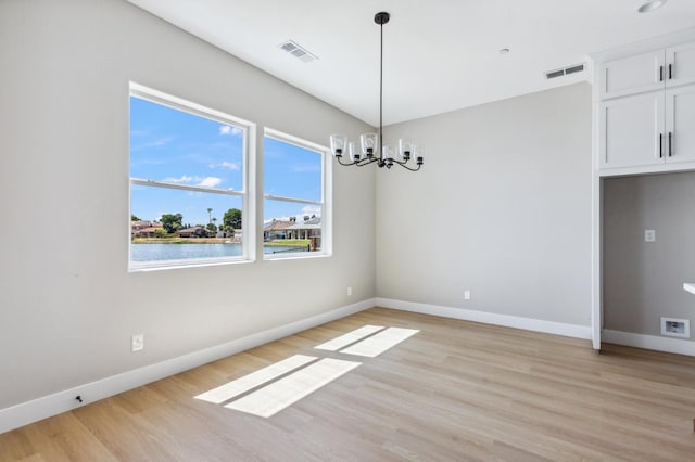 8385 Lake Shore Dr, Chowchilla, CA 93610 - unfurnished dining area with a chandelier, light wood-style flooring, and baseboards