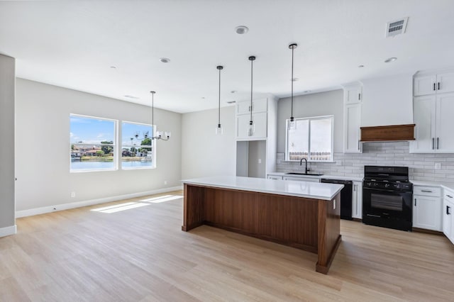 8385 Lake Shore Dr, Chowchilla, CA 93610 - kitchen with black appliances, a kitchen island, decorative backsplash, light wood-style flooring, and a sink