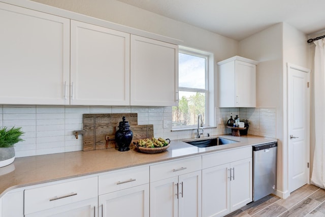 1151 Maclure Ave W, Madera, CA 93636 - kitchen featuring a sink, stainless steel dishwasher, white cabinetry, light wood finished floors, and tasteful backsplash