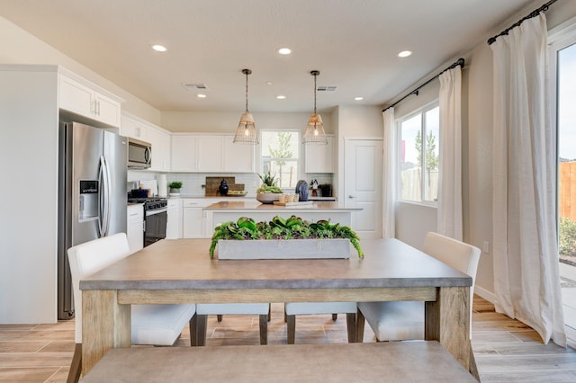 1151 Maclure Ave W, Madera, CA 93636 - kitchen with appliances with stainless steel finishes, light wood finished floors, backsplash, white cabinets, and recessed lighting