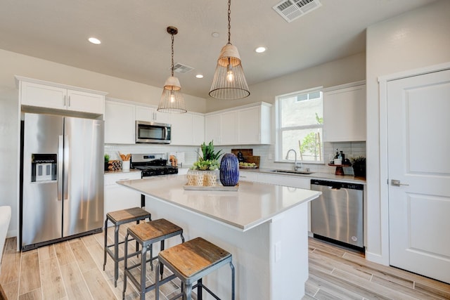 1151 Maclure Ave W, Madera, CA 93636 - kitchen with stainless steel appliances, a sink, light wood-style floors, backsplash, and recessed lighting