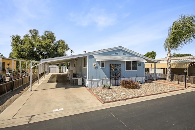 2627 W Midvalley, Visalia, CA 93277 - manufactured / mobile home featuring an attached carport, driveway, and central AC unit