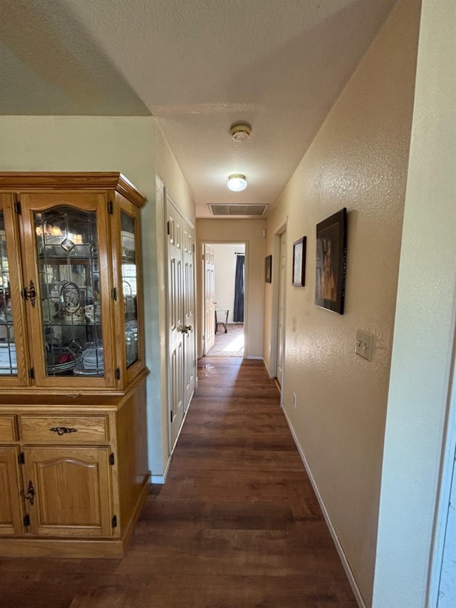 32633 Rd 222, North Fork, CA 93643 - hallway featuring dark wood finished floors, baseboards, a textured wall, and a textured ceiling