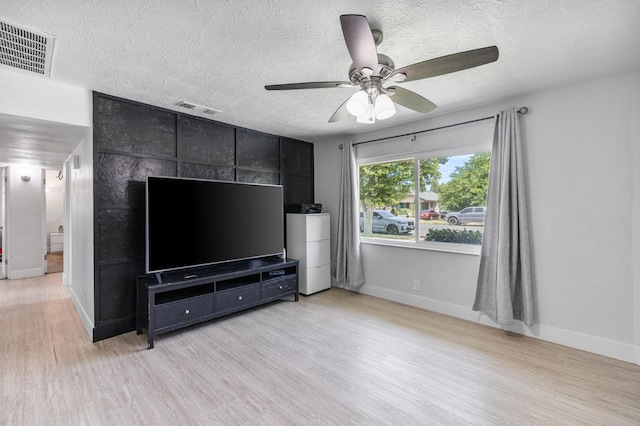 958 E Cornell Ave, Fresno, CA 93704 - living area featuring light wood-style floors, a textured ceiling, ceiling fan, and baseboards