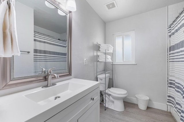 958 E Cornell Ave, Fresno, CA 93704 - bathroom featuring toilet, vanity, wood finished floors, a shower with shower curtain, and baseboards