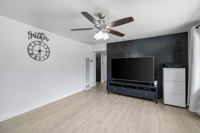 958 E Cornell Ave, Fresno, CA 93704 - unfurnished living room with light wood-type flooring, a heating unit, a ceiling fan, a textured ceiling, and baseboards
