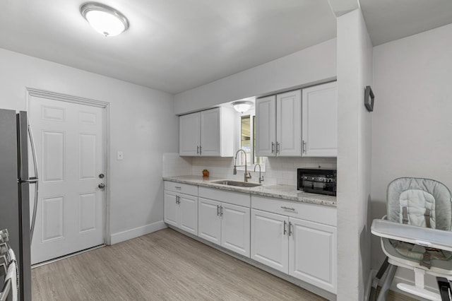 958 E Cornell Ave, Fresno, CA 93704 - kitchen with freestanding refrigerator, a sink, backsplash, and white cabinetry