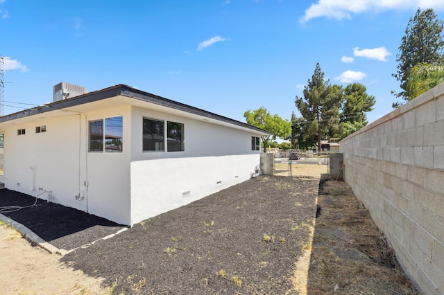 4641 E Weldon Ave, Fresno, CA 93703 - view of side of home with stucco siding and a gate