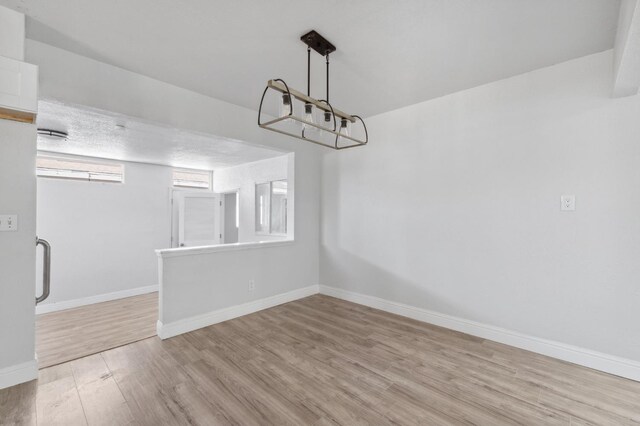 4641 E Weldon Ave, Fresno, CA 93703 - unfurnished dining area featuring wood finished floors, baseboards, and a chandelier