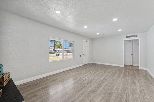 4641 E Weldon Ave, Fresno, CA 93703 - unfurnished living room featuring light wood-style floors, recessed lighting, baseboards, and a textured ceiling