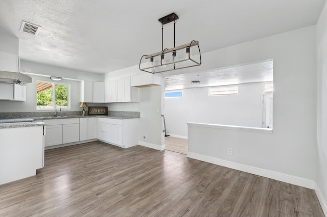 4641 E Weldon Ave, Fresno, CA 93703 - kitchen featuring white cabinets, wood finished floors, baseboards, and a sink