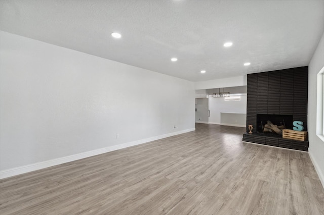 4641 E Weldon Ave, Fresno, CA 93703 - unfurnished living room featuring light wood-style flooring, baseboards, recessed lighting, and a fireplace