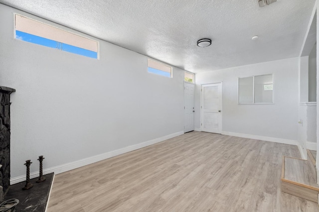 4641 E Weldon Ave, Fresno, CA 93703 - unfurnished living room with wood finished floors, a textured ceiling, and baseboards