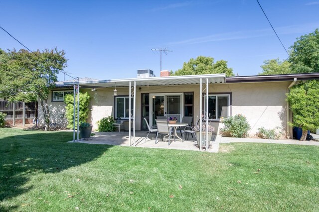 3979 N Pleasant Ave, Fresno, CA 93705 - back of house featuring stucco siding, a patio area, a lawn, and a chimney