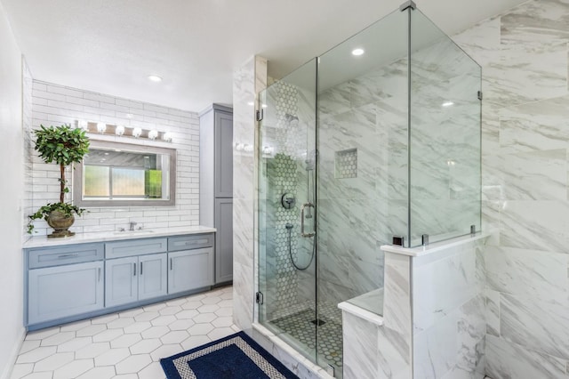 4341 W Dakota Ave, Fresno, CA 93722 - full bath featuring a marble finish shower, vanity, recessed lighting, tile patterned flooring, and backsplash