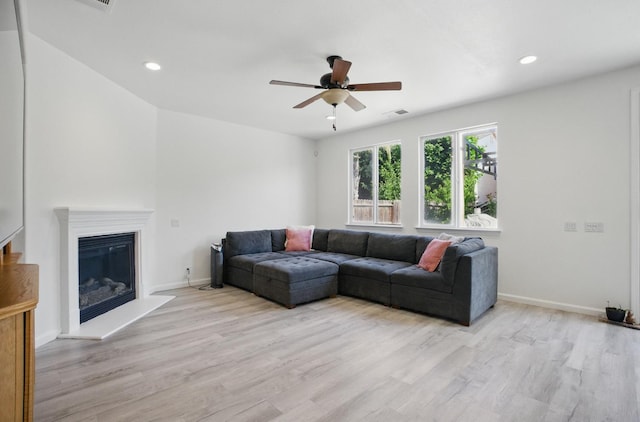 1216 Avignon Dr, Merced, CA 95348 - living area with a ceiling fan, light wood-type flooring, baseboards, recessed lighting, and a glass covered fireplace