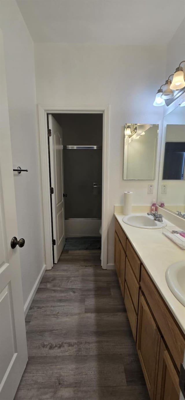 1216 Avignon Dr, Merced, CA 95348 - full bath with wood finished floors, double vanity, toilet, baseboards, and shower / tub combination