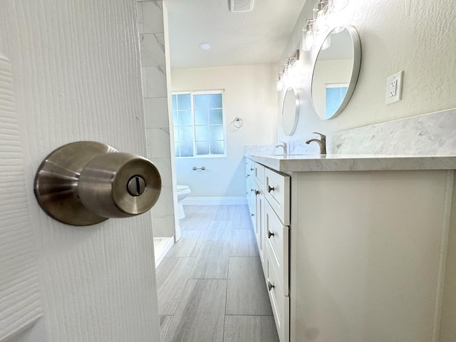 4221 E Grant Ave, Fresno, CA 93702 - full bath with double vanity, toilet, and wood finished floors