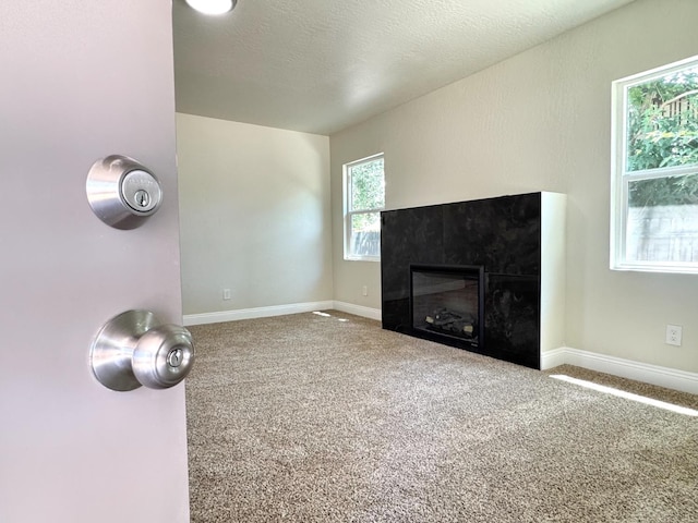 4221 E Grant Ave, Fresno, CA 93702 - unfurnished living room with a tiled fireplace, carpet floors, and baseboards