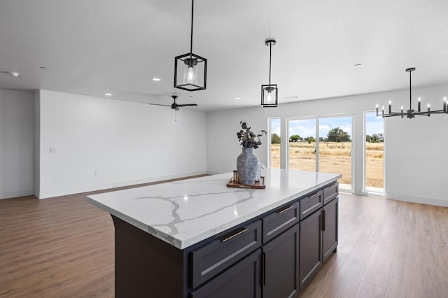 25900 Tanforan Dr, Madera, CA 93638 - kitchen with wood finished floors, a center island, a chandelier, recessed lighting, and open floor plan