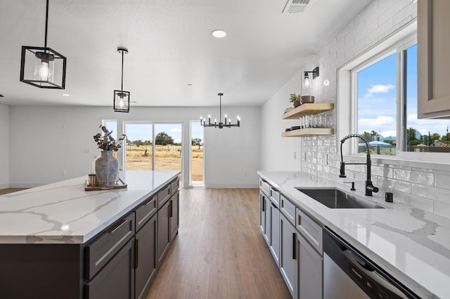 25900 Tanforan Dr, Madera, CA 93638 - kitchen featuring a sink, stainless steel dishwasher, wood finished floors, a chandelier, and decorative backsplash