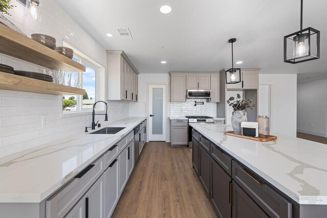25900 Tanforan Dr, Madera, CA 93638 - kitchen with a sink, appliances with stainless steel finishes, open shelves, wood finished floors, and decorative backsplash