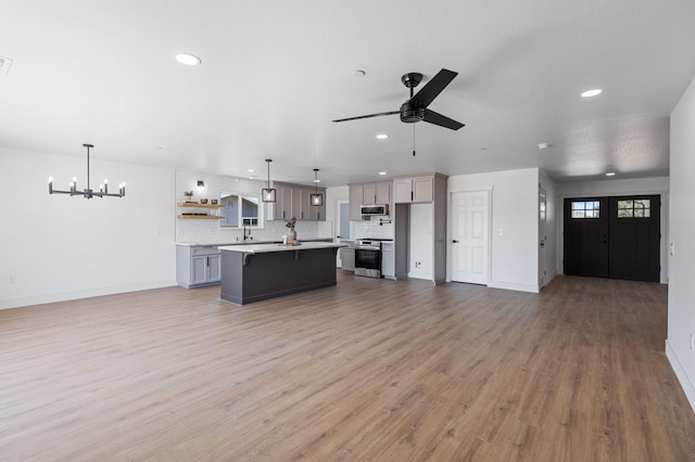 25900 Tanforan Dr, Madera, CA 93638 - unfurnished living room featuring recessed lighting, a chandelier, ceiling fan, light wood-style flooring, and baseboards