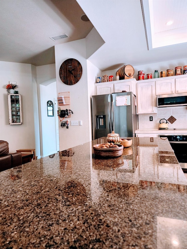 2513 Twain Ave, Clovis, CA 93611 - kitchen featuring stainless steel refrigerator with ice dispenser, wall oven, dark stone counters, decorative backsplash, and white cabinets