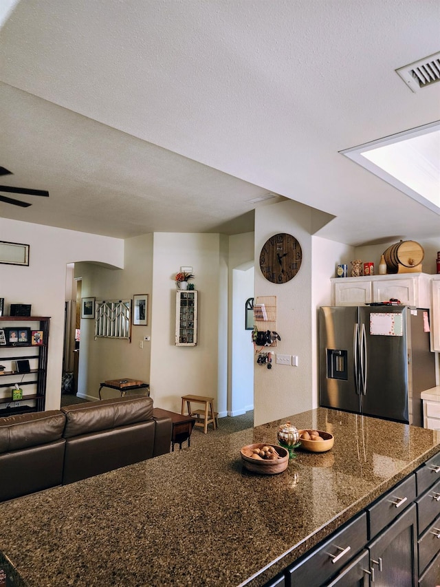 2513 Twain Ave, Clovis, CA 93611 - kitchen featuring stainless steel fridge, open floor plan, dark stone countertops, and a textured ceiling