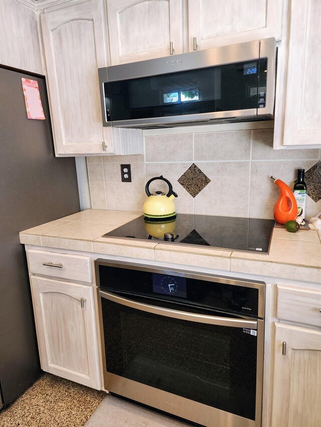 2513 Twain Ave, Clovis, CA 93611 - kitchen with stainless steel appliances, backsplash, and tile countertops