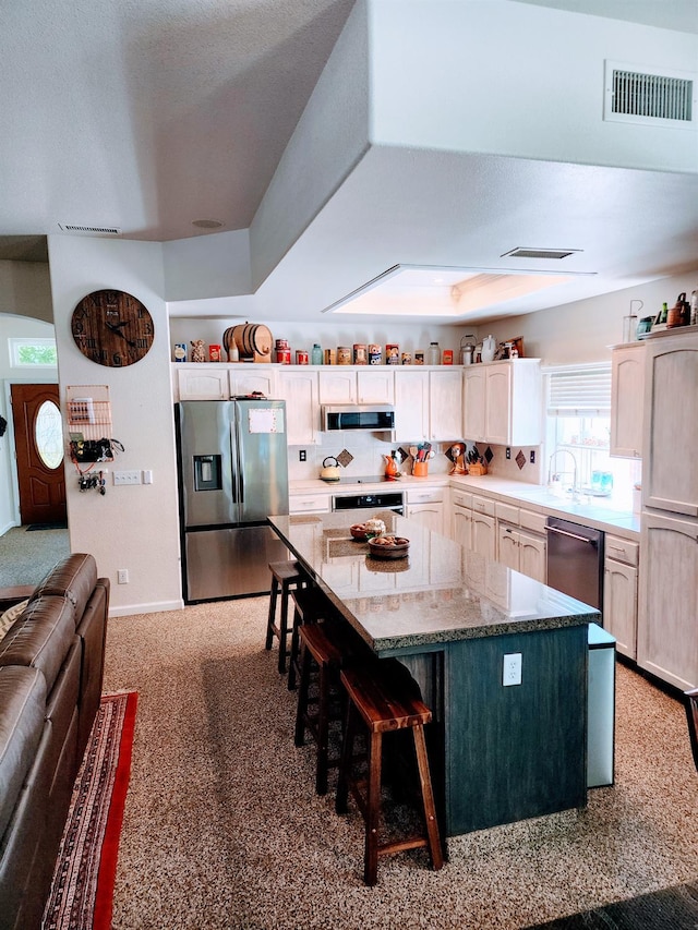 2513 Twain Ave, Clovis, CA 93611 - kitchen featuring stainless steel appliances, a center island, carpet, a breakfast bar, and light stone countertops