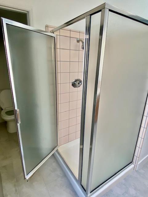 485 E Alluvial Ave Unit 102, Fresno, CA 93720 - full bathroom with toilet, a shower stall, and tile patterned flooring