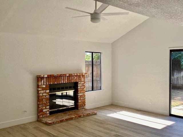 485 E Alluvial Ave Unit 102, Fresno, CA 93720 - unfurnished living room with wood finished floors, a fireplace, vaulted ceiling, baseboards, and ceiling fan
