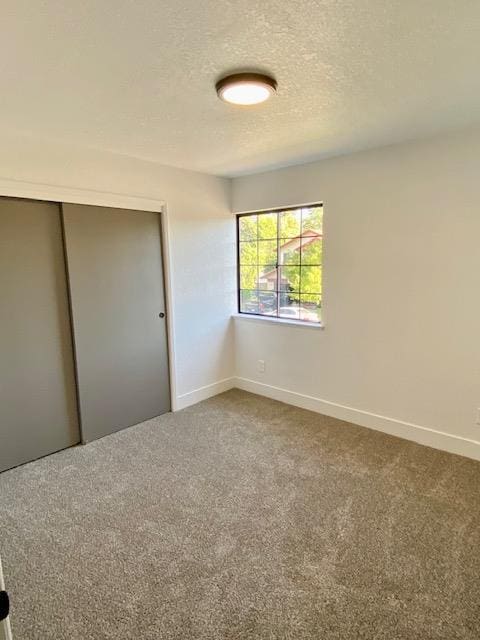 485 E Alluvial Ave Unit 102, Fresno, CA 93720 - unfurnished bedroom featuring a textured ceiling, carpet flooring, baseboards, and a closet