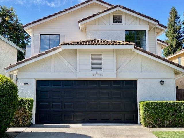 485 E Alluvial Ave Unit 102, Fresno, CA 93720 - view of front of home featuring a tiled roof, a garage, and stucco siding