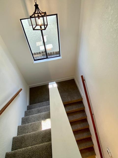 485 E Alluvial Ave Unit 102, Fresno, CA 93720 - staircase featuring carpet flooring and a chandelier